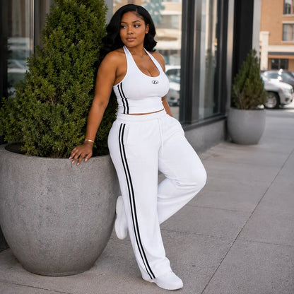 Ensemble sport blanc bandes noires – pose adossée à un pot de fleurs