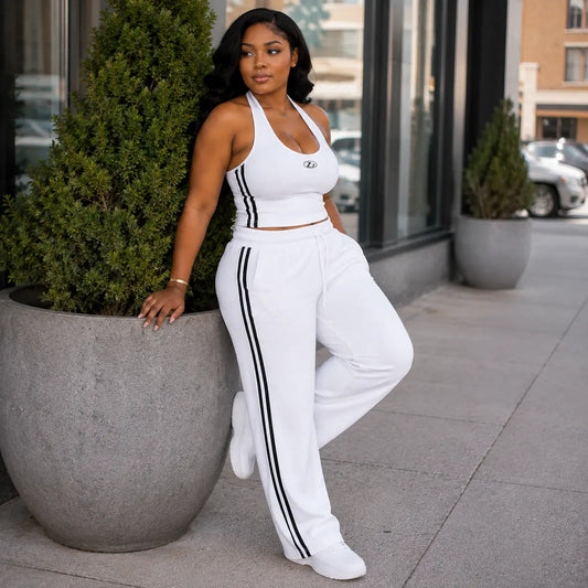 Ensemble sport blanc bandes noires – pose adossée à un pot de fleurs